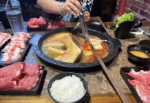 Restaurant review: Hero Hotpot excels in taste and affordability Customer holds utensil over hot pot with two sides