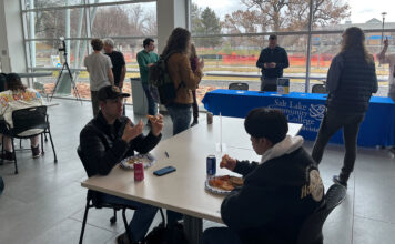 School staff, faculty bring attention to STEM center with ‘(PI)zza’ party Students eating pizza inside the Dumke Center for STEM Learning