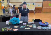Mental wellness event at SLCC encourages students to ‘feel’ their emotions Jasmine Wesley standing at table full of merchandise