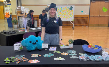 Mental wellness event at SLCC encourages students to ‘feel’ their emotions Jasmine Wesley standing at table full of merchandise