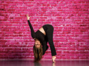 SLCC Dance Co. president discusses the state of dance at the college Lauren Uribe striking a dance pose in front of pink brick wall