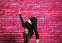 SLCC Dance Co. president discusses the state of dance at the college Lauren Uribe striking a dance pose in front of pink brick wall