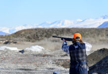 Shooting clubs at two Utah colleges rely on responsible gun ownership Person wearing orange hat points a shotgun at a clay target out of view