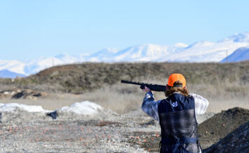 Shooting clubs at two Utah colleges rely on responsible gun ownership Person wearing orange hat points a shotgun at a clay target out of view