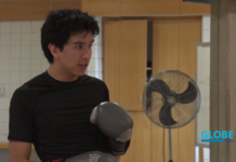 Exercise more than just your mind with free classes at SLCC Student wearing black t-shirt and gray boxing gloves in a gym