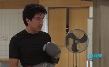 Exercise more than just your mind with free classes at SLCC Student wearing black t-shirt and gray boxing gloves in a gym