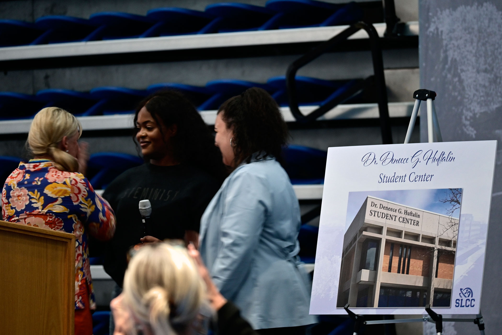 Joyce Wambuyi and Tashelle Wright unveiling a poster announcing the Dr. Deneece G. Huftalin Student Center