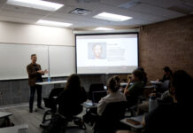Veteran Boston Globe editor gives talk at Salt Lake Community College Seated audience listening to guest lecturer James Dao, whose picture and information is displayed on a projection screen