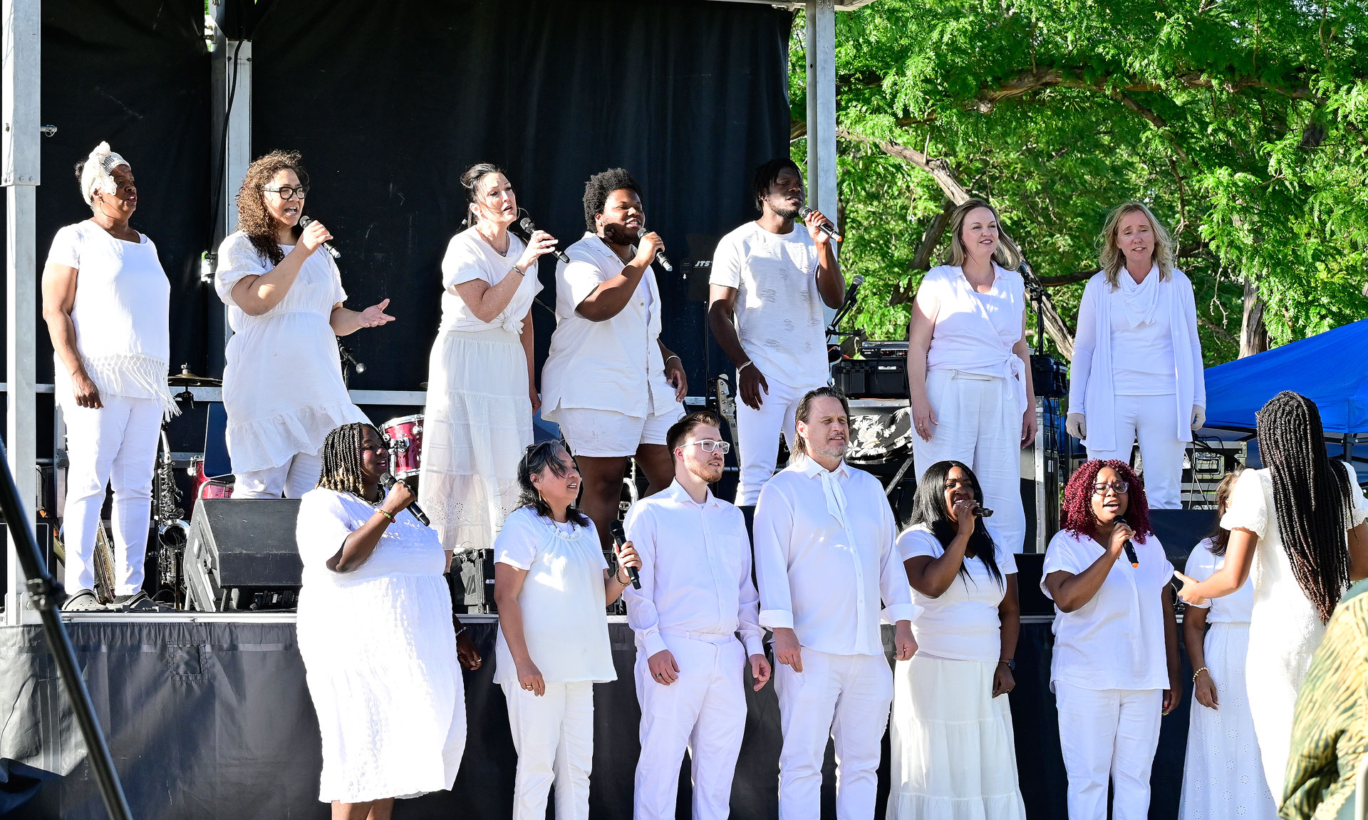 Two rows of choir singers performing on outdoor stage