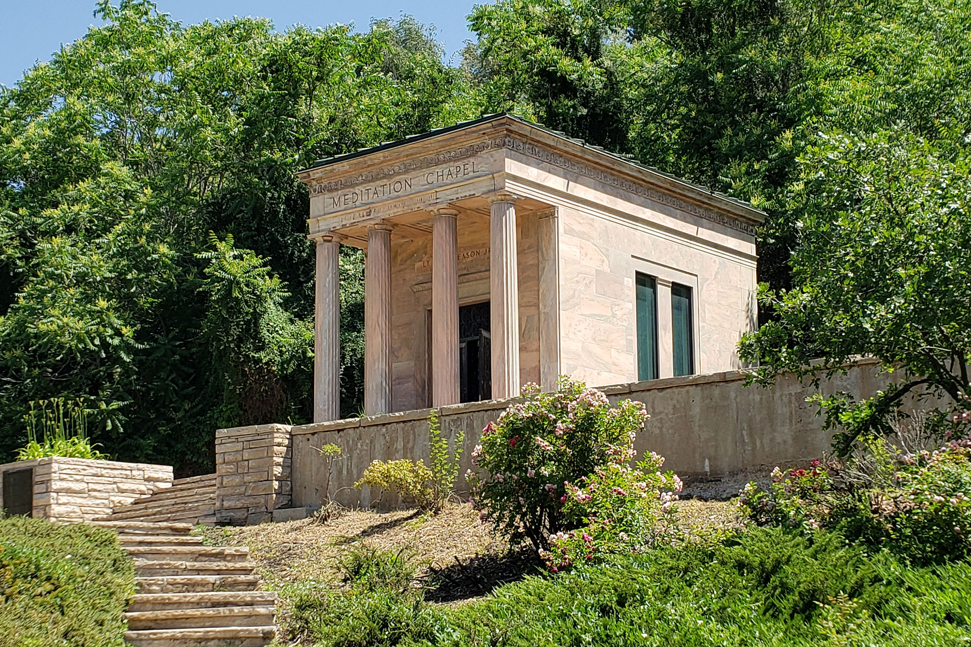 Stone building surrounded by trees and shrubbery