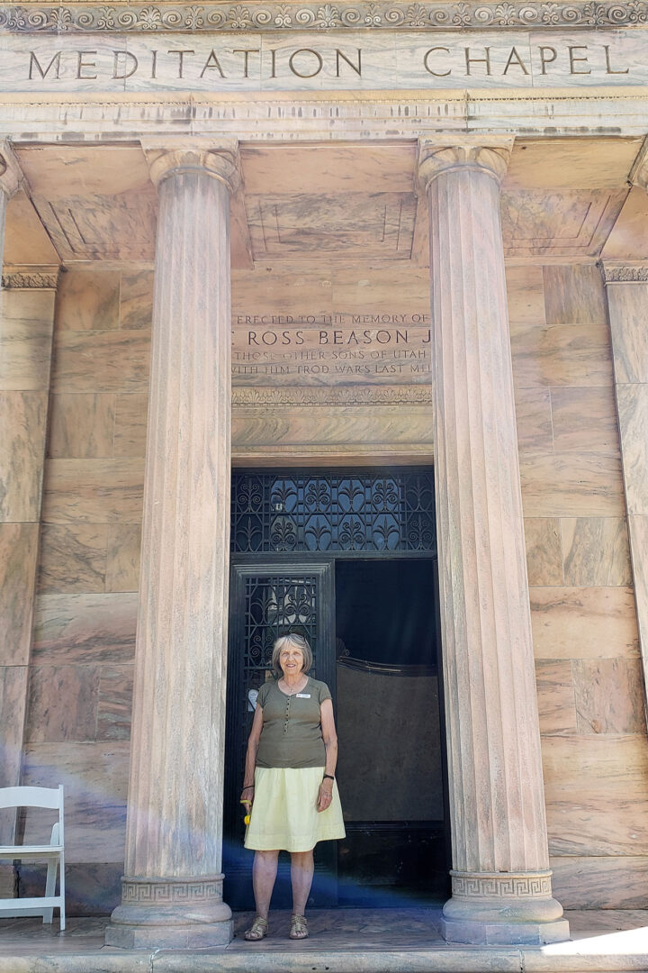Woman standing at entrance of stone chapel