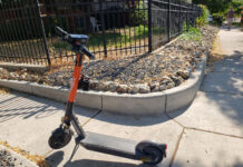 Shared mobility devices present some safety issues for riders and others e-scooter standing on a sidewalk