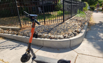 Shared mobility devices present some safety issues for riders and others e-scooter standing on a sidewalk