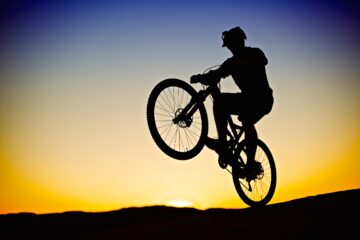 Several athletes with Utah ties to compete at the Paris Olympics Silhouette of man pulling a classic wheelie on a mountain bike