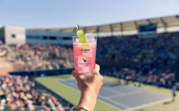 Honey Deuce: The sensational US Open phenomenon and how you can try it Hand holding a honey deuce cocktail with a tennis court in the background