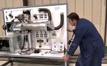 Students can fly high with SLCC Aviation Maintenance Program Aviation professor moving a display board of engine parts