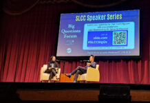Pulitzer-winning author Viet Thanh Nguyen discusses reframing the ‘refugee crisis’ during SLCC keynote Two people sitting in yellow chairs on theatre stage with projection screen displaying event information