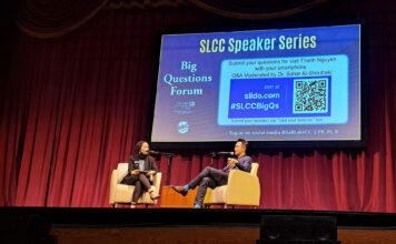 Pulitzer-winning author Viet Thanh Nguyen discusses reframing the ‘refugee crisis’ during SLCC keynote Two people sitting in yellow chairs on theatre stage with projection screen displaying event information