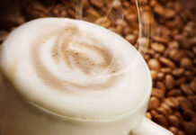 Fall’s favorite drink: the pumpkin spice latte A cup of coffee with coffee beans in background