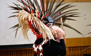 Photos: SLCC community celebrates Día de los Muertos Dancer wearing traditional attire and headdress while blowing a conch shell