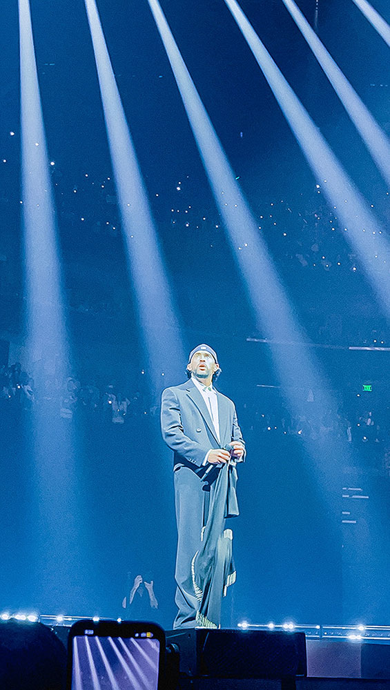 Bad Bunny standing on stage under spotlights