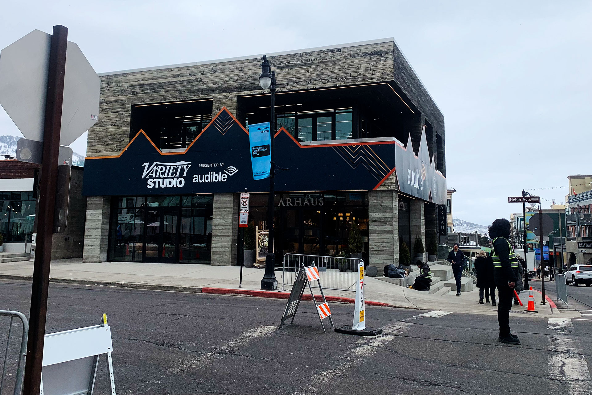 Volunteer crossing guard standing on street near Arhaus Furniture building