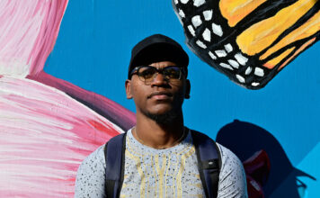 SLCC Hometowns: Jevah France Jevah standing in front of the Peace and Justice Garden mural
