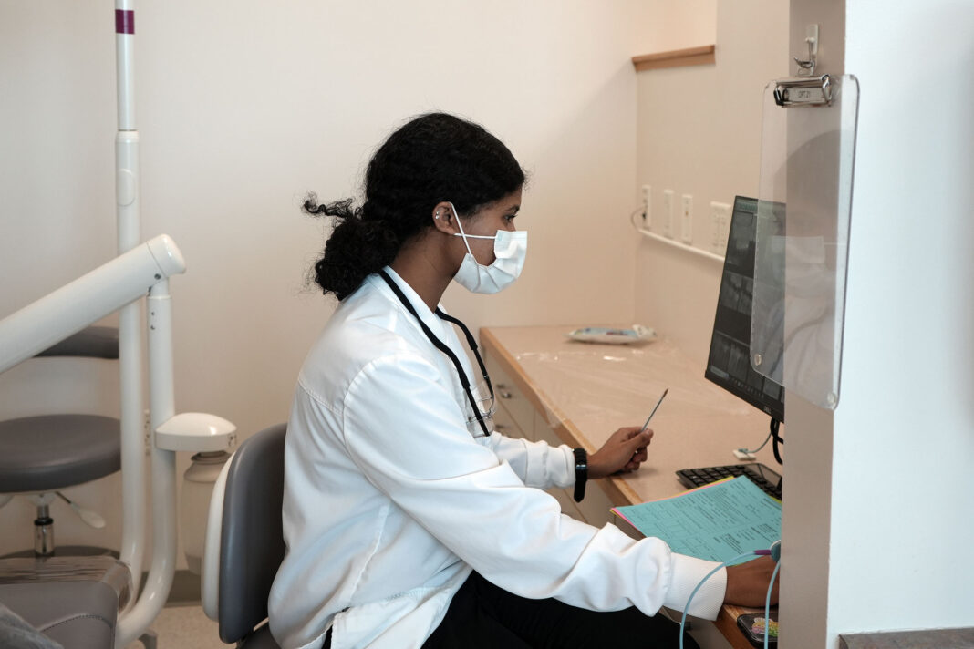 Dental hygiene student seated at a computer workstation