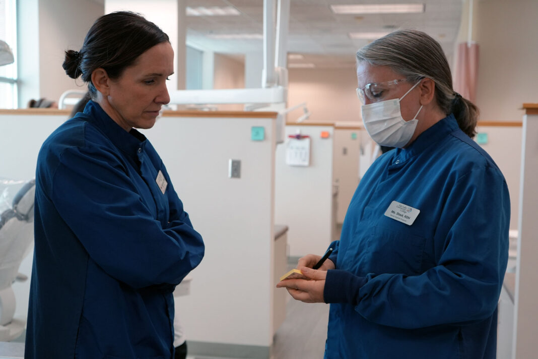 Two dental hygiene instructors having a discussion in the clinic