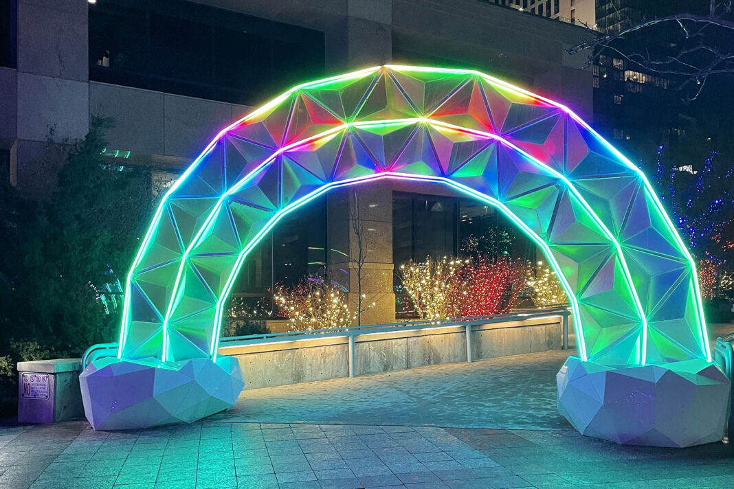 Multicolored illuminated rainbow standing over a walkway