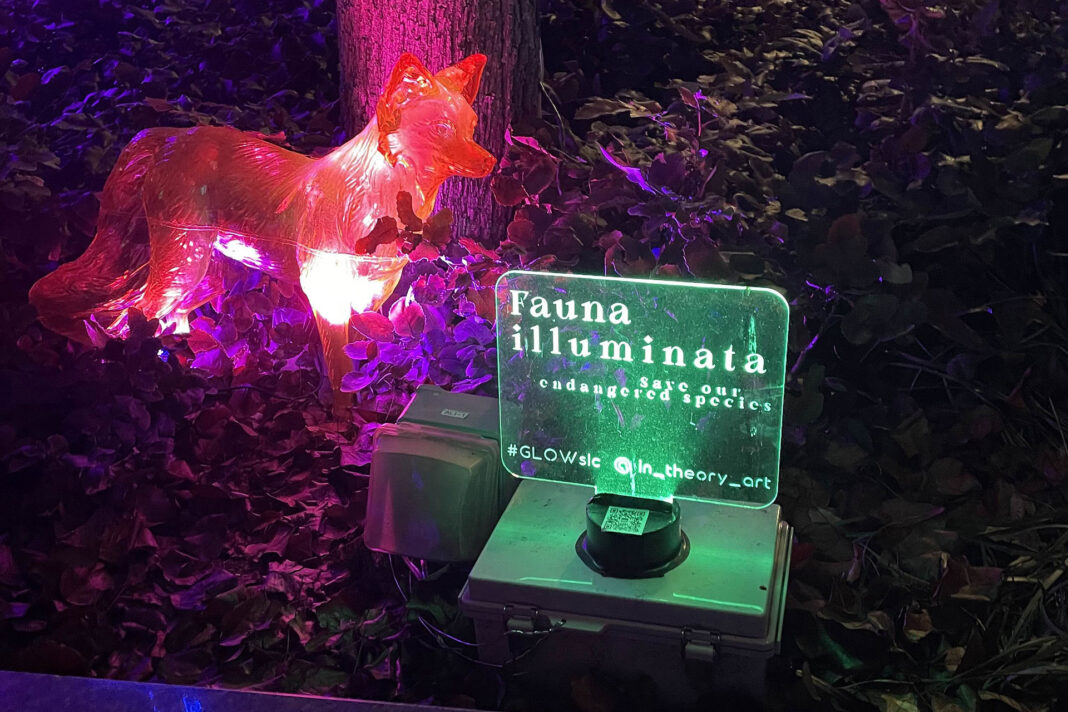 A fox figurine illuminated in red near an illuminated "fauna illuminata" sign