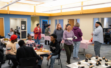 Students learn art, science of candle making Group of people making candles in a large meeting room