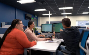 ‘No Cap’: How Gen Z slang is shaking up office talk Three coworkers collaborating at a computer desk