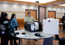 SLCC community builds winter shelters for outdoor cats Lead volunteer assembling a cat shelter as others watch
