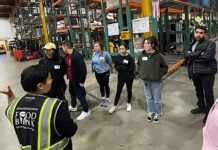 Spring break alternative provides a meaningful experience Food bank employee wearing a fluorescent vest speaking to volunteers