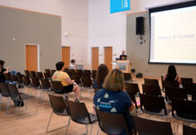 Gender & Sexuality Student Resource Center honors Stonewall legacy, examines modern communication Several people seated inside multipurpose room listening to lecturer standing at a podium