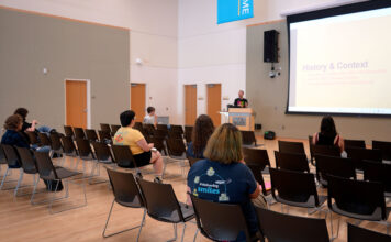 Gender & Sexuality Student Resource Center honors Stonewall legacy, examines modern communication Several people seated inside multipurpose room listening to lecturer standing at a podium