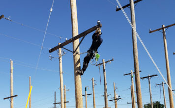 SLTech program graduates celebrate with a lineworker’s rodeo Lineworker moving a pin insulator while on a power pole