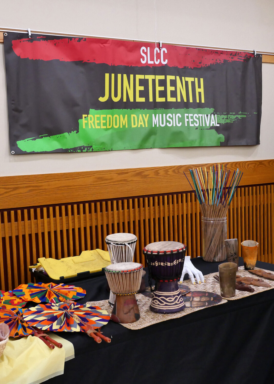 SLCC Juneteenth banner hanging on wall above table with African art
