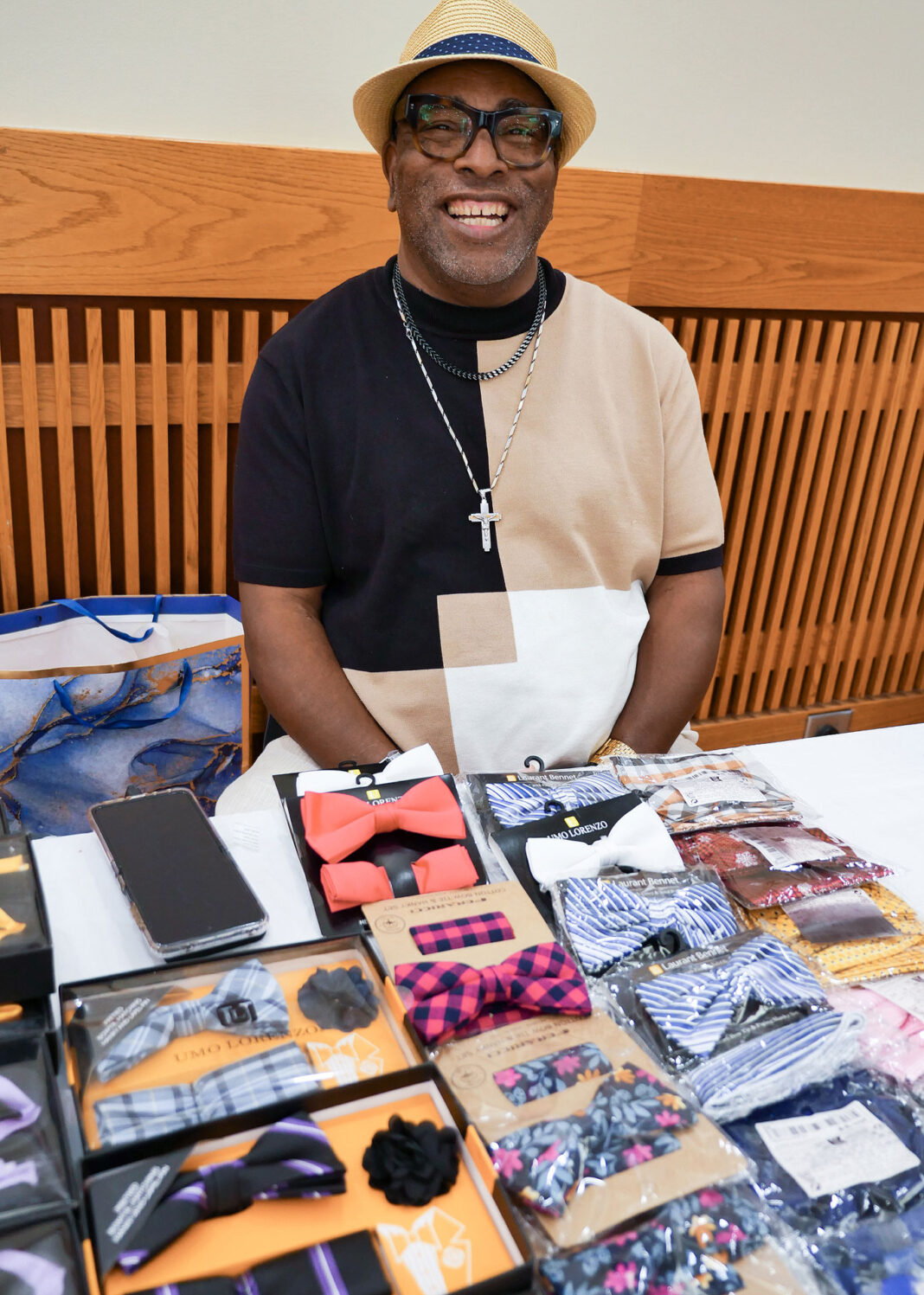 Johnny Mayo sitting at table with his bowtie creations