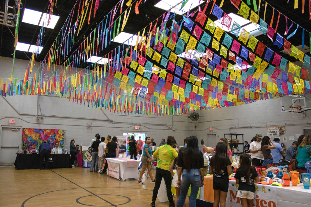 People inside a large room decorated with with multicolored paper overhead