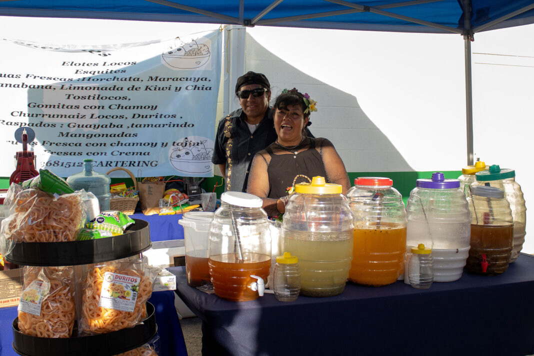 Juli and Julian smiling while working at their food station