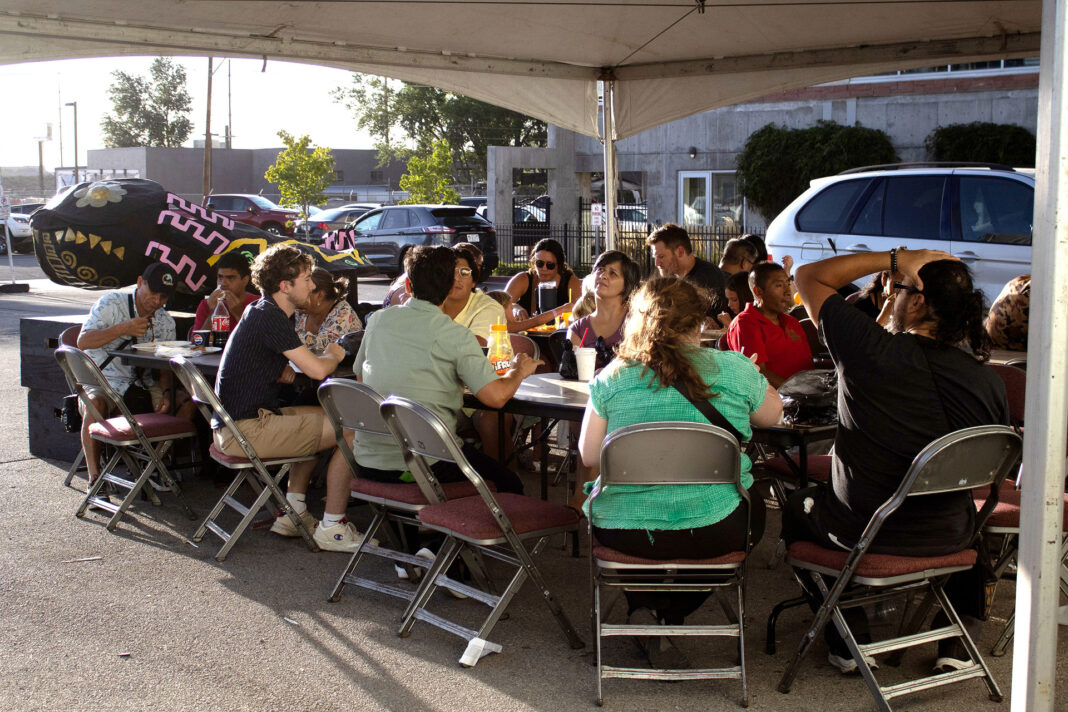People eating outdoors underneath a canopy