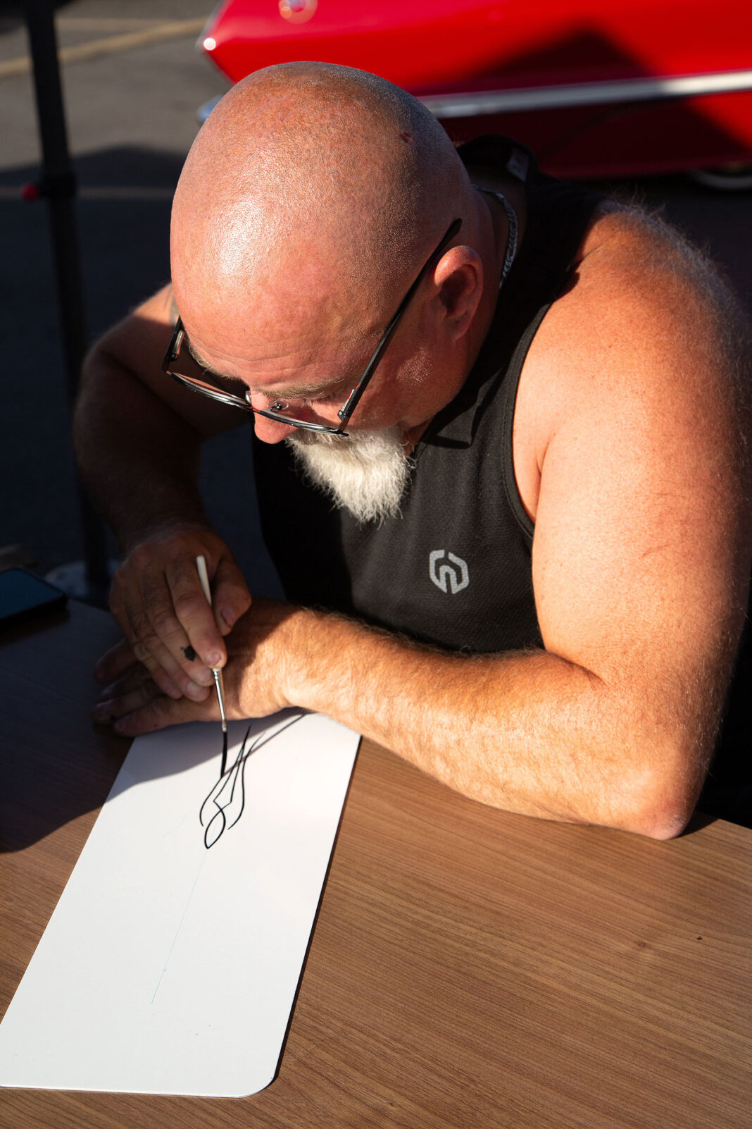 Man drawing a pinstripe design on a piece of paper