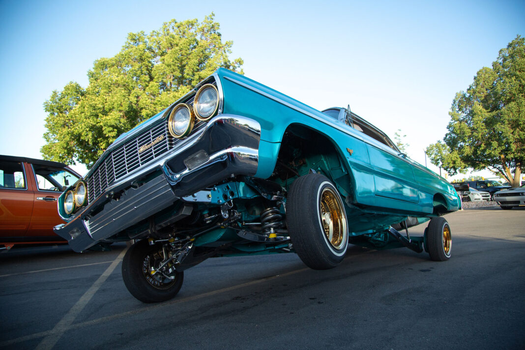 Teal-colored Chevy Impala with gold rims
