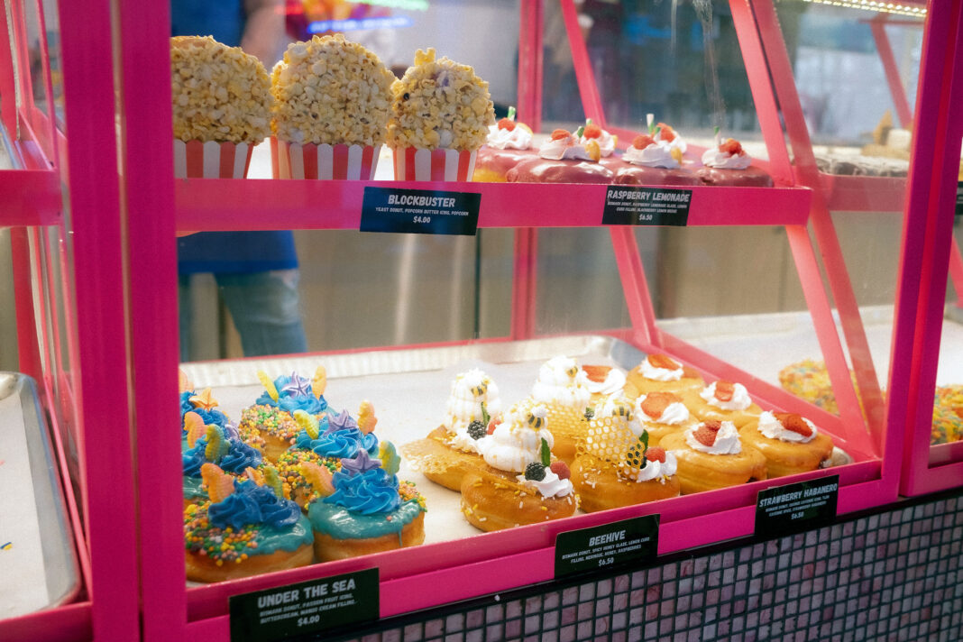 Various donuts being displayed in a glass case for sale