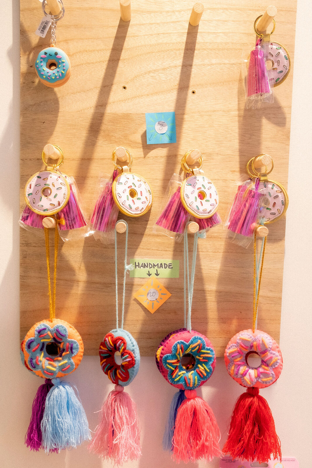 Donut keychains and yarn decorations hanging on a peg board