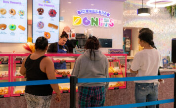 The Other Side’s donut shop tells community, ‘Donut give up on your dreams’ Multiple customers standing in a donut shop while Charlene works