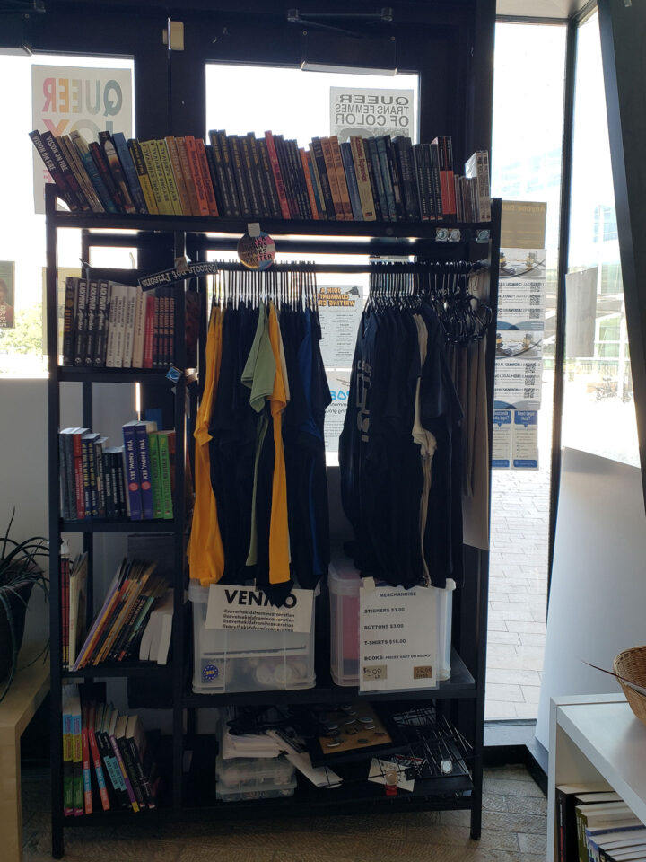 Storage rack of merchandise, including books and t-shirts