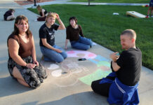 Back to school, with a bash! Four people contributing to a chalk art drawing